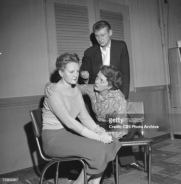 German-born American actor Mike Nichols stands while American actress Mary Astor , seated right, comforts actress Vivian Nathan in the CBS television...