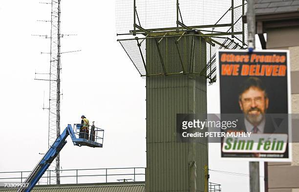 United Kingdom: A poster of Sinn Fein President Gerry Adams is pictured as one of the British Army's former watchtowers is dismantled in CrossMaglen,...