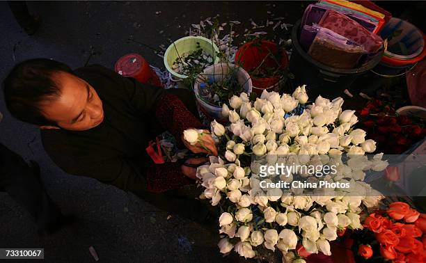 Vendor arranges roses at a flower shop on February 13, 2007 in Chongqing Municipality, China. As the Valentines Day festival draws near, sales of...