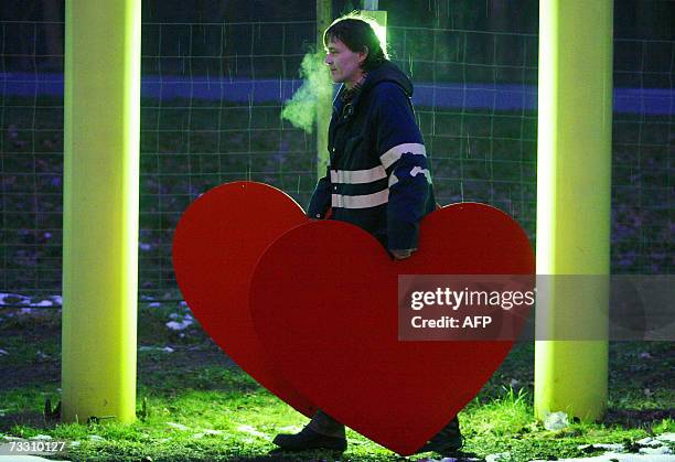 Man carries two large cut-out roses for decoration of a flower shop in Borgsdosf, easten Germany. Business is booming in the trade of flowers as...