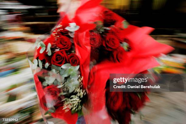 Flower seller carries out bouquets of roses on February 13, 2007 in London, England. As the Valentines Day festival draws near, sales of flowers are...