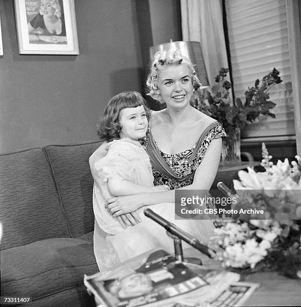 American actress Jayne Mansfield sits on a couch and holds her daughter Jayne Marie Mansfield in her lap as they prepare to appear on the CBS...