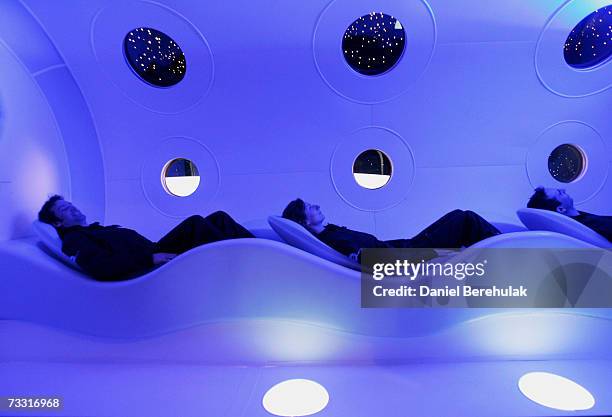 Virgin employees sit in the cabin of a prototype Virgin Galactic SpaceShipTwo spacecraft at the Science Museum on February 14, 2007 in London,...