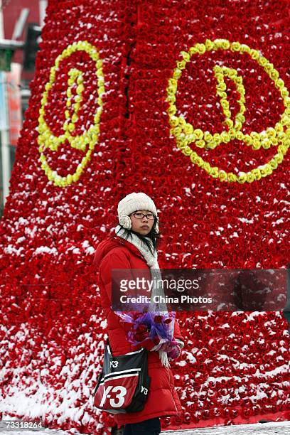 Woman walks past a giant rose tree on a street on February 14, 2007 in Changchun of Jilin Province, China. Valentines Day is a traditional boon to...