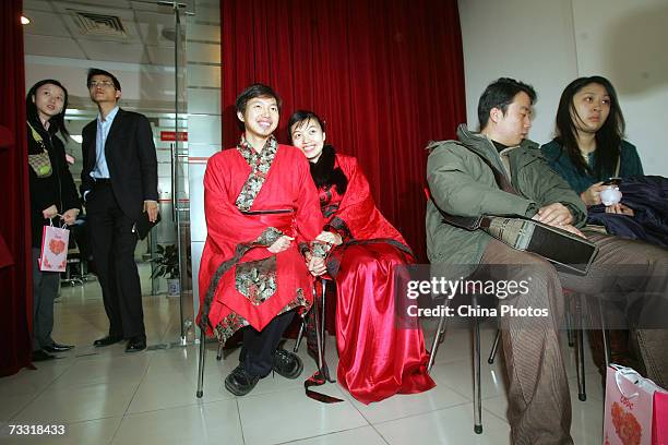 Newlywed couple Sun Yi and Cai Lingling, dressed in traditional costumes, wait to register their marriage at the Xuhui District Civil Affairs Bureau...