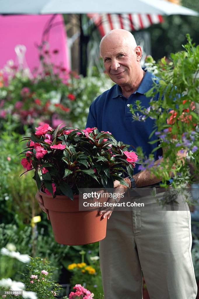 Senior man in garden centre choosing plants