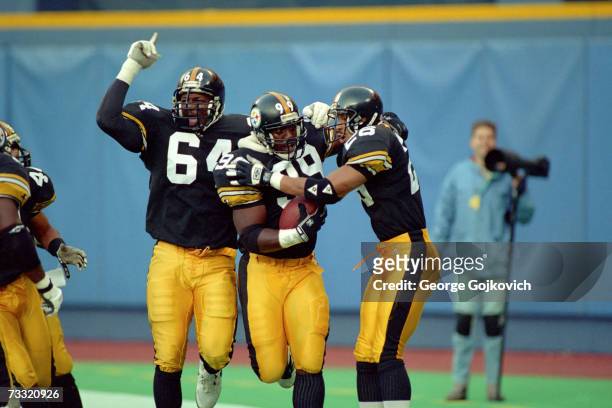 Linebacker Levon Kirkland of the Pittsburgh Steelers is congratulated by defensive lineman Kenny Davidson and defensive back Rod Woodson after...