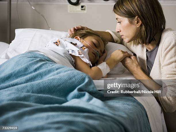 woman holding hands with young girl in hospital - kind im krankenhaus stock-fotos und bilder