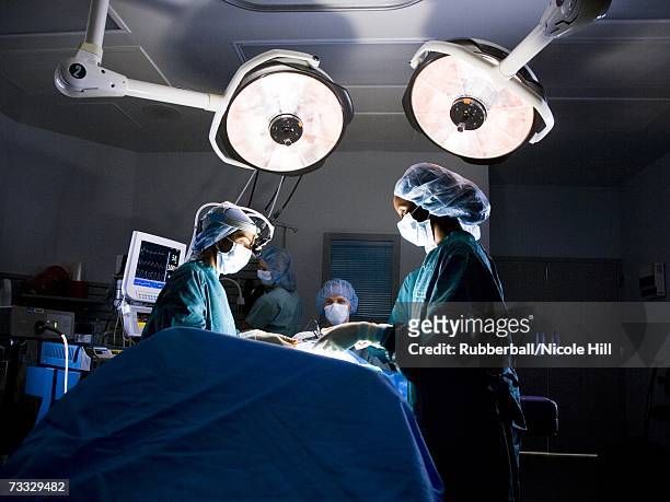 female nurse and surgeon in scrubs during surgery - surgery stock pictures, royalty-free photos & images