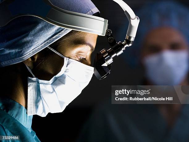 female doctor in scrubs with head light in surgery - doctor profile view stock pictures, royalty-free photos & images