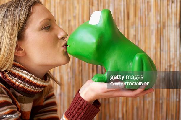 young woman kissing a toy frog, close-up - woman frog hand stockfoto's en -beelden