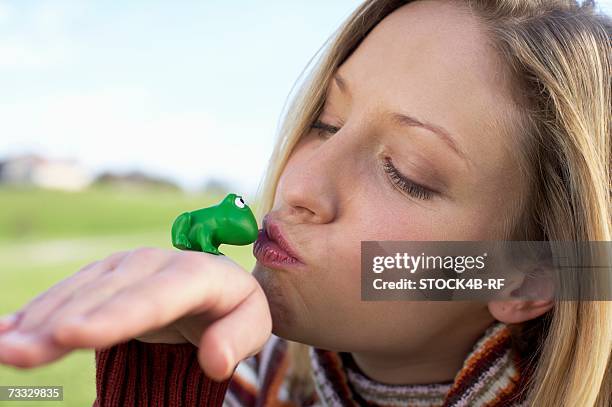 young woman kissing a toy frog, close-up - woman frog hand stockfoto's en -beelden