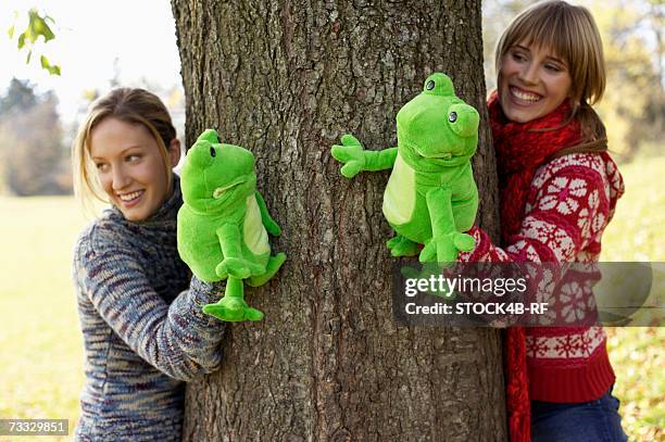 two young women with frog hand puppets, selective focus - woman frog hand stock-fotos und bilder