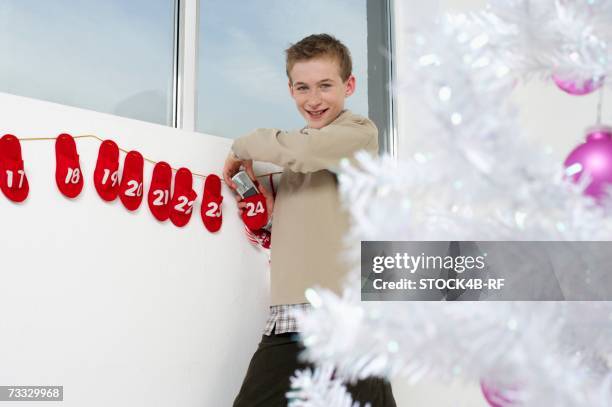 boy finding a mobile phone in an advent calendar - 12 day advent calendar stock pictures, royalty-free photos & images
