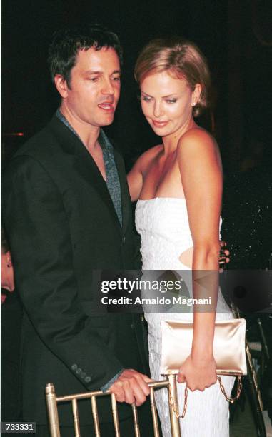Actress Charlize Theron cuddles up with her boyfriend Stephan Jenkins October 24, 2000 during The Fashion Group International's presentation of...