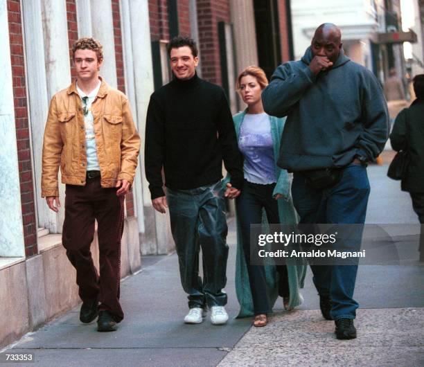 Sync band members Justin Timberlake, left, JC Chasez, center, and Chasez's girlfriend, right, stroll down Madison Avenue October 24, 2000 before...