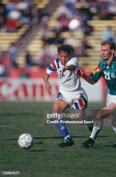 American footballer Cobi Jones clashes with German player Dieter Eilts as they both run for the ball during the international friendly match between...