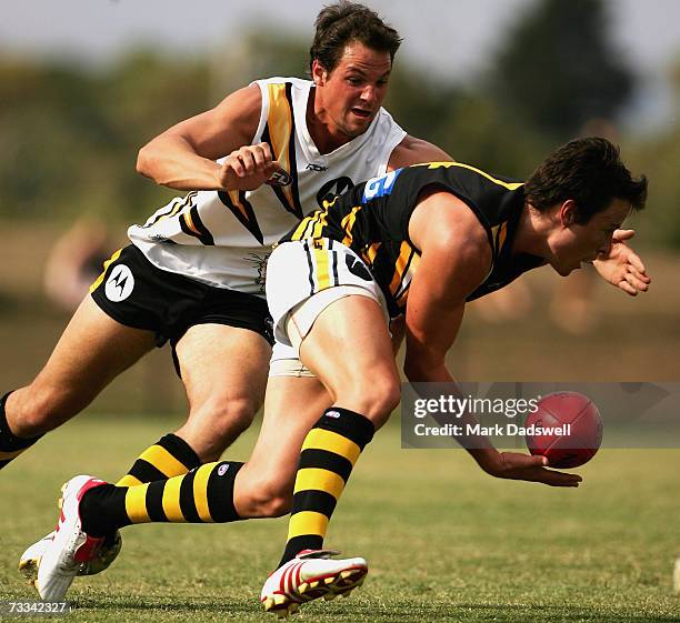 Andrew Raines of Team Rawlings gathers the ball as he is tackled by Graham Polak of Team King during the Richmond Tigers intra-club AFL match at...