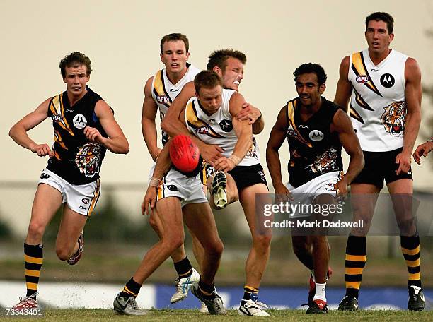 Nathan Brown of Team King gets a kick away despite the efforts of Dean Polo of Team Rawlings during the Richmond Tigers intra-club AFL match at Casey...