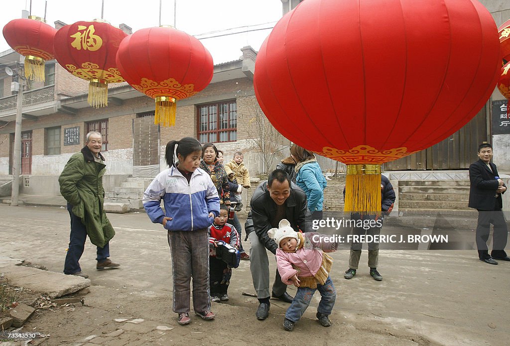 Villagers display red lanterns in front...