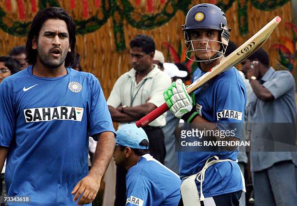 Indian cricketer Sourav Ganguly gets ready to bat as team mate Mahendra Singh Dhoni walks past during a training session at the Andhra Cricket...