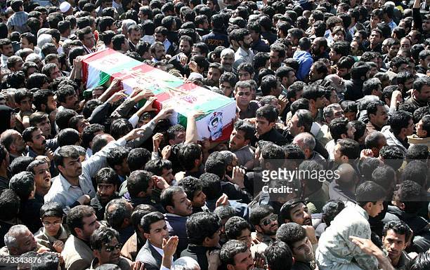 Iranian men carry a coffin during the funeral of 11 Revolutionary Guards who were killed two days ago when a booby-trapped car exploded in front of a...