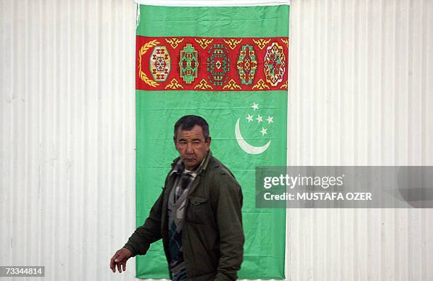 Man passes by a Turkmenistan flag 14 February 2007 in Ashgabat, Turkmenistan. AFP PHOTO/MUSTAFA OZER