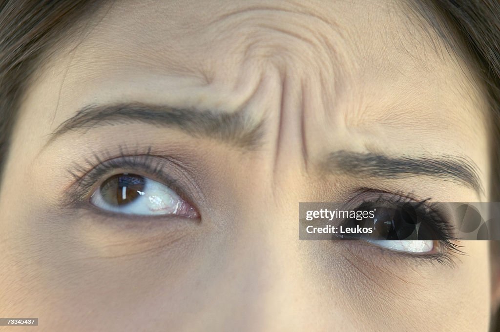 Woman with wrinkled brow, high section, close-up of eyes