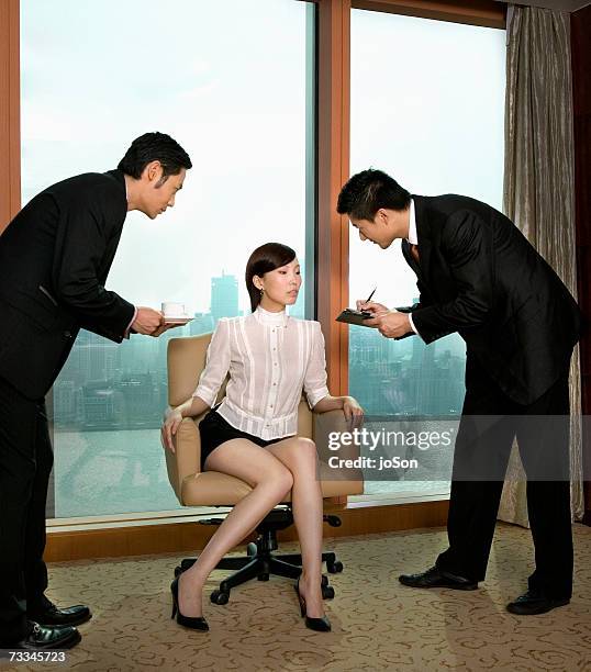 businesswoman sitting with businessmen bending over her - bending over in skirt stock-fotos und bilder