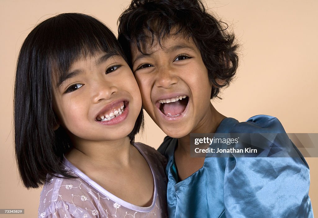 Two girls (5-6) smiling cheek to cheek, portrait