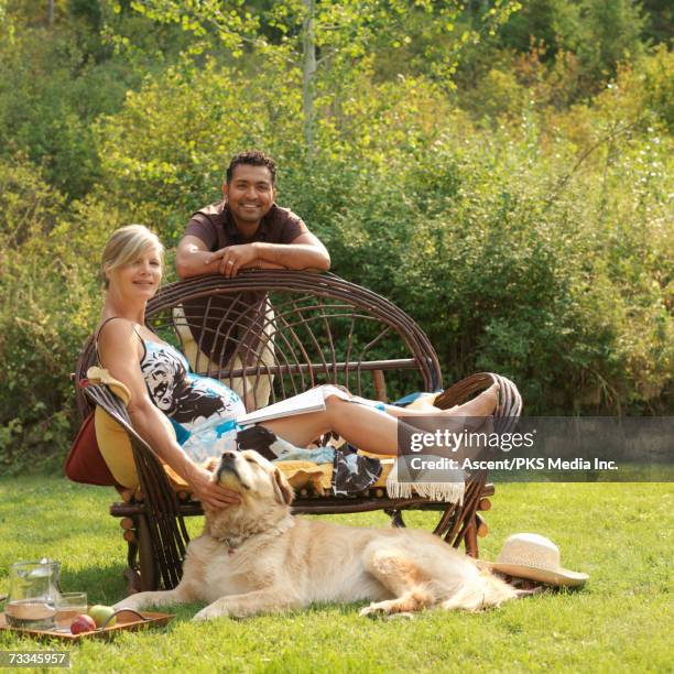 couple with pregnant wife relaxing in yard with dog, portrait - one animal stock pictures, royalty-free photos & images
