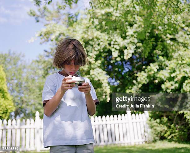 boy (8-9) looking at digital camera - fishkin stock pictures, royalty-free photos & images