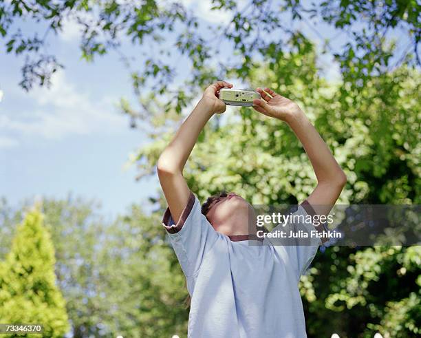 boy (8-9) looking up at digital camera - fishkin stock pictures, royalty-free photos & images