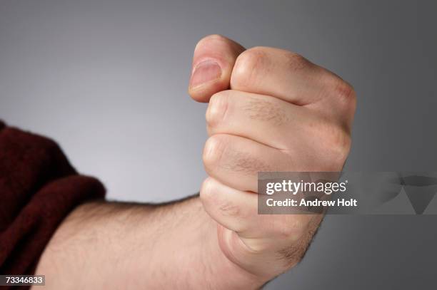 man clenching fist, close-up - poing photos et images de collection