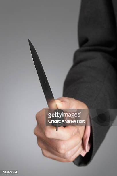 businessman holding knife, close-up - business revenge stock pictures, royalty-free photos & images