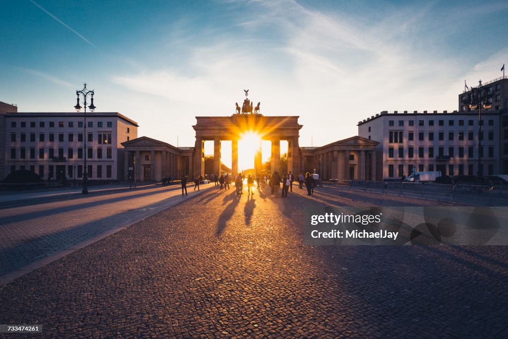 Straße, die zum Brandenburger Tor gegen den Himmel bei Sonnenuntergang führt