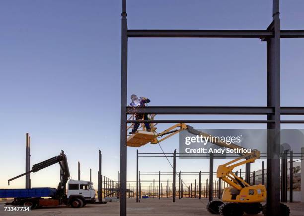 worker on cherry picker at construction site - cherry picker stock pictures, royalty-free photos & images
