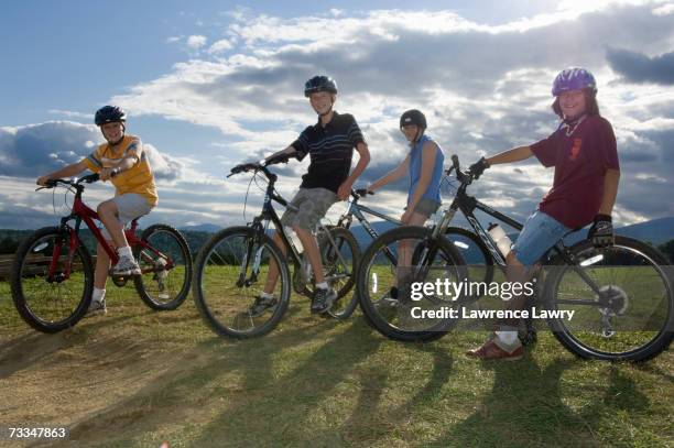 four teenagers (12-14) riding bicycles, portrait - casco bici foto e immagini stock