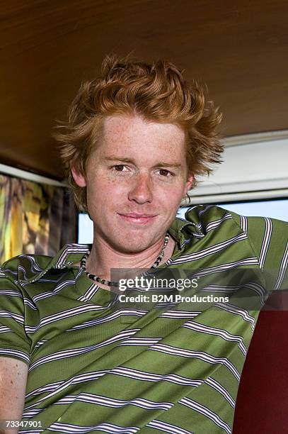 Young man sitting in camper van smiling, portrait