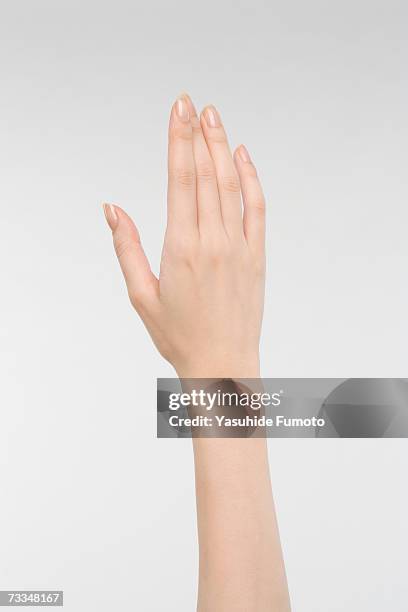 young woman holding out hand, close-up on hand - finger studio close up stock-fotos und bilder