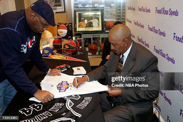 Former NBA star George Gervin signs autographs and greets customers at the Front Row Sporting Goods store during NBA All-Star Week festivities at the...