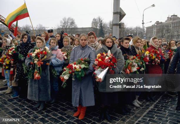 Group of women bring flowers to a funeral held for the victims killed in a demonstration against the Red Army's seizure of the television...