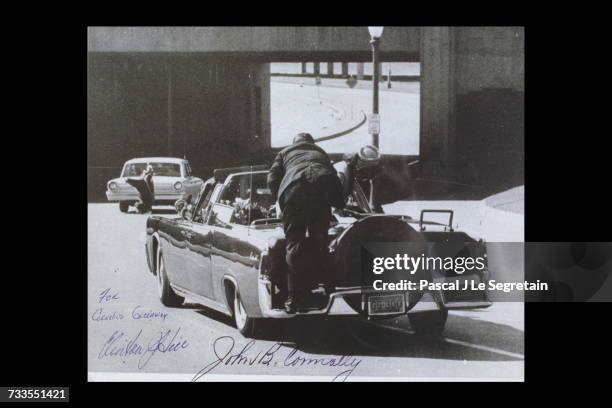 S car as Hill Clint climbs in. A gunshot can be seen on the windscreen.