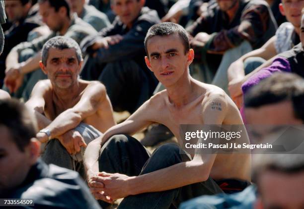 Emaciated Bosnian prisoners of war are detained at the Manjaca concentration camp during the Yugoslavian Civil War. The Serb camp, which detained...