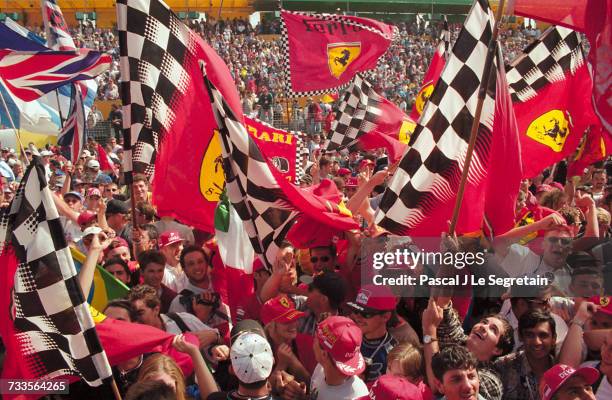 Crowd of enthusiastic Formula One fans wave Ferrari flags at the 1997 Australian Grand Prix.