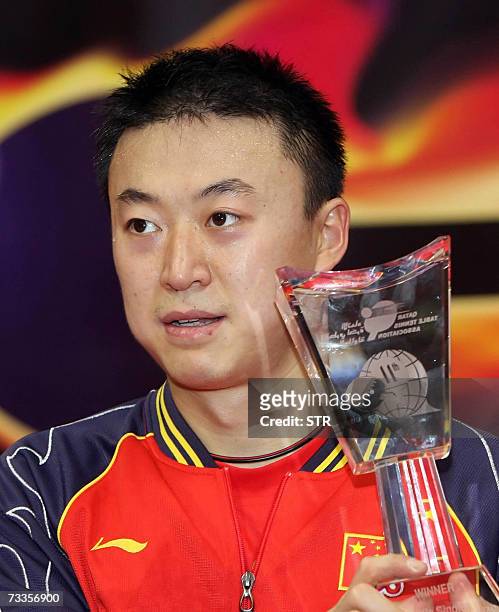 China's Ma Lin holds his trophy after beating his compatriot Wang Liqin in the men's single final table tennis match during the 11th Qatar Open Table...