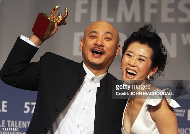 Chinese director Wang Quan'an and his lead actress Nan Yu hold up their trophy during the closing press conference of the 57th Berlinale...