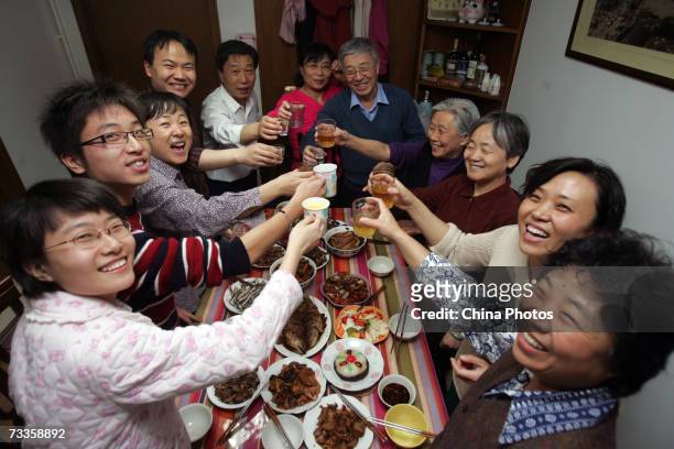 Members of a family toast during New Year's Eve dinner at a resident's home on February 17, 2007 in Beijing, China. The Chinese lunar New Year, or...