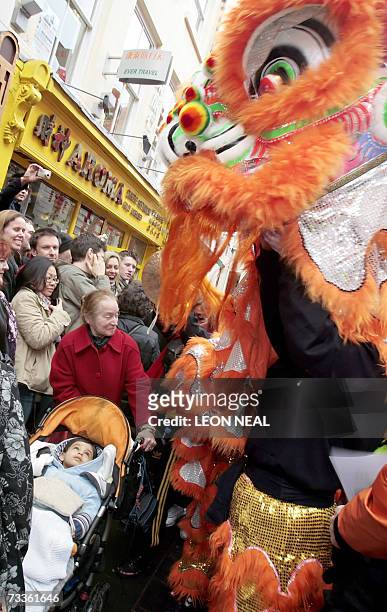 London, UNITED KINGDOM: The Chinese New Year parade revellers watch the dragon's dance during the traditional celebrations in London's Chinatown...