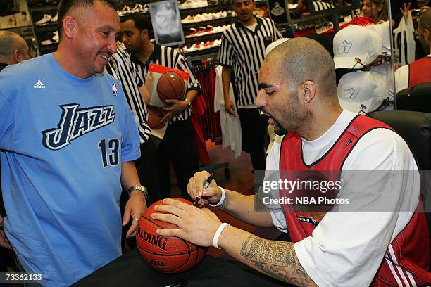 Carlos Boozer of the Utah Jazz signs autographs and greets customers during an appearance for NBA All-Star Week at Champs Sports Goods at the Las...